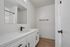 Modern bathroom featuring sleek white cabinetry, a large mirror, and elegant marble countertop with a stylish black faucet.