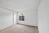 Bright and airy room with plush carpeting, natural light from large windows, and neutral tones creating a serene ambiance.