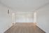 Spacious minimalist room with elegant wood flooring and bright natural lighting, ideal for a modern living area or home office setup.