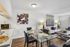 Modern apartment interior showcasing a chic living and dining area with stylish decor, glass dining table, cozy seating, and contemporary art on gleaming hardwood floors.