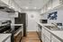 Modern and sleek kitchen with stainless steel appliances, elegant white cabinetry, and a stylish tile backsplash.