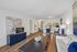 Modern open-concept living room with sleek hardwood floors, stylish art, elegant dining area, and inviting kitchen space.