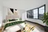 Elegant bedroom with modern decor, featuring large windows offering stunning city and lake views.