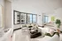 Elegant urban apartment with panoramic city and lake views, featuring a cozy living area and modern furnishings.