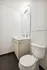 Modern minimalist bathroom with sleek fixtures, large mirror, and elegant design for a refreshing retreat.