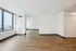 Bright and spacious open-plan apartment with elegant wooden flooring, large windows, and captivating city views.