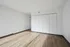 Modern empty room with elegant wood flooring and sleek white closets, perfect for customization.