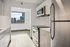 Modern kitchen with sleek cabinets, stainless steel appliances, and a stunning city view through a large window.