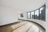 Bright, spacious apartment with panoramic city and lake views through large curved windows, capturing modern elegance and natural light.
