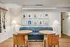 Chic lounge area featuring blue sofa, round wooden tables, and warm-toned chairs. Elegant wall art enhances the modern decor.