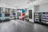 Modern fitness room featuring exercise equipment, vibrant yoga balls, and a stocked snack cooler, offering an inviting space for health enthusiasts.