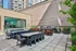 Chic outdoor patio with modern dining tables, BBQ grills, and vibrant urban views, perfect for entertainment and relaxation.