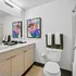 Modern bathroom with sleek vanity, vibrant abstract artwork, and elegant decor accents.