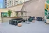 Chic urban outdoor lounge area with stylish seating, large mural, and lush greenery, perfect for relaxation and entertaining.