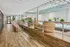 Inviting indoor pool area with lush plants, chic wicker seating, and natural light streaming through ceiling windows.