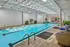 Luxurious indoor pool area featuring sleek design, ample natural light, and relaxing seating with vibrant decor.
