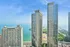Breathtaking aerial view of luxurious waterfront apartments with stunning lakefront backdrop and vibrant cityscape.