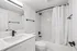 Modern bathroom featuring sleek white cabinetry, elegant black fixtures, and a pristine tiled shower with a luxurious feel.