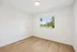 Bright and airy room with beautiful wooden flooring and a scenic window view, perfect for creating a cozy space.
