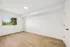 Bright and airy room with sleek wood flooring and a large window offering scenic views.