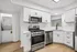 Modern kitchen with sleek stainless steel appliances, elegant white cabinetry, and convenient in-unit laundry.