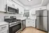 Modern kitchen with sleek white cabinetry, stainless steel appliances, and elegant subway tile backsplash.