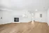 Bright and spacious living area with elegant fireplace, sleek hardwood floors, and modern design.