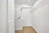 Modern laundry room with sleek stacked washer and dryer, featuring ample storage space and elegant wooden flooring.