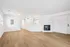 Modern living room with sleek wood flooring, a cozy fireplace, and abundant natural light.