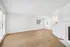 Bright and spacious living room with elegant wood flooring and abundant natural light, featuring a stylish fireplace for cozy ambiance.