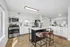 Modern kitchen with sleek white cabinets, stainless steel appliances, and a central island with stylish seating, exuding contemporary elegance.