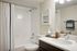 Modern bathroom featuring a sleek vanity with a stylish faucet, elegant decor, and a pristine bathtub with a chic shower curtain.