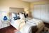 Chic bedroom showcasing a plush bed with luxurious bedding, stylish nightstands, and elegant decor, offering a serene and inviting ambiance.