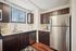 Modern kitchen with sleek stainless steel appliances, dark wood cabinets, and ample countertop space.