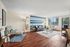Inviting living room with elegant wood floors, contemporary furniture, stylish accent wall, and abundant natural light.