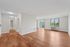 Bright and spacious living area featuring sleek hardwood floors, large windows, and modern lighting, perfect for enjoying comfort and style.
