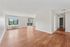 Bright and spacious apartment with elegant hardwood floors, large windows offering scenic views, and an inviting open layout.