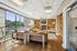 Modern apartment lounge with large windows, cozy seating area, and stylish built-in bookshelves filled with decor.