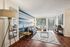 Inviting living room with cozy seating, a stylish blue accent wall, and large windows for abundant natural light.