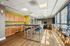 Inviting recreation room with modern kitchenette, high tables, and colorful bar stools, perfect for social gatherings.
