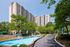 Elegant high-rise apartment building with lush landscaping and a charming fountain, offering scenic views and modern living.