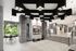 Elegant, modern apartment lobby with a striking geometric ceiling, large windows offering lush garden views, and a sophisticated gray interior.