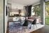 Chic and modern living space with large windows, plush pink sofa, and stylish geometric rug, offering a blend of comfort and elegance.