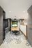 Modern office space with geometric tiled flooring, sleek table, and black chairs under stylish pendant lighting.