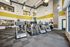 Modern fitness center with state-of-the-art treadmills and ample natural light, featuring high ceilings and stylish interior design.