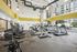 Bright, modern gym with state-of-the-art exercise machines, large windows, and stylish lighting.