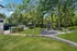 Serene landscaped outdoor space with a sparkling pool, cozy gazebo, and lush green surroundings.