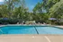Inviting outdoor swimming pool surrounded by lush greenery and relaxing lounge chairs, perfect for a leisurely afternoon.