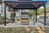 Inviting outdoor BBQ area under a modern gazebo, featuring a sleek stainless steel grill for perfect entertaining.
