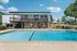 Inviting apartment complex with a pristine outdoor pool, sunlit deck, and modern architectural design, perfect for relaxation and leisure.